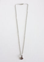 silver stainless steel chain with a small stamped heart charm on white background