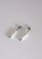 A pair of silver drop earrings with hematite beads, displayed against a white background.