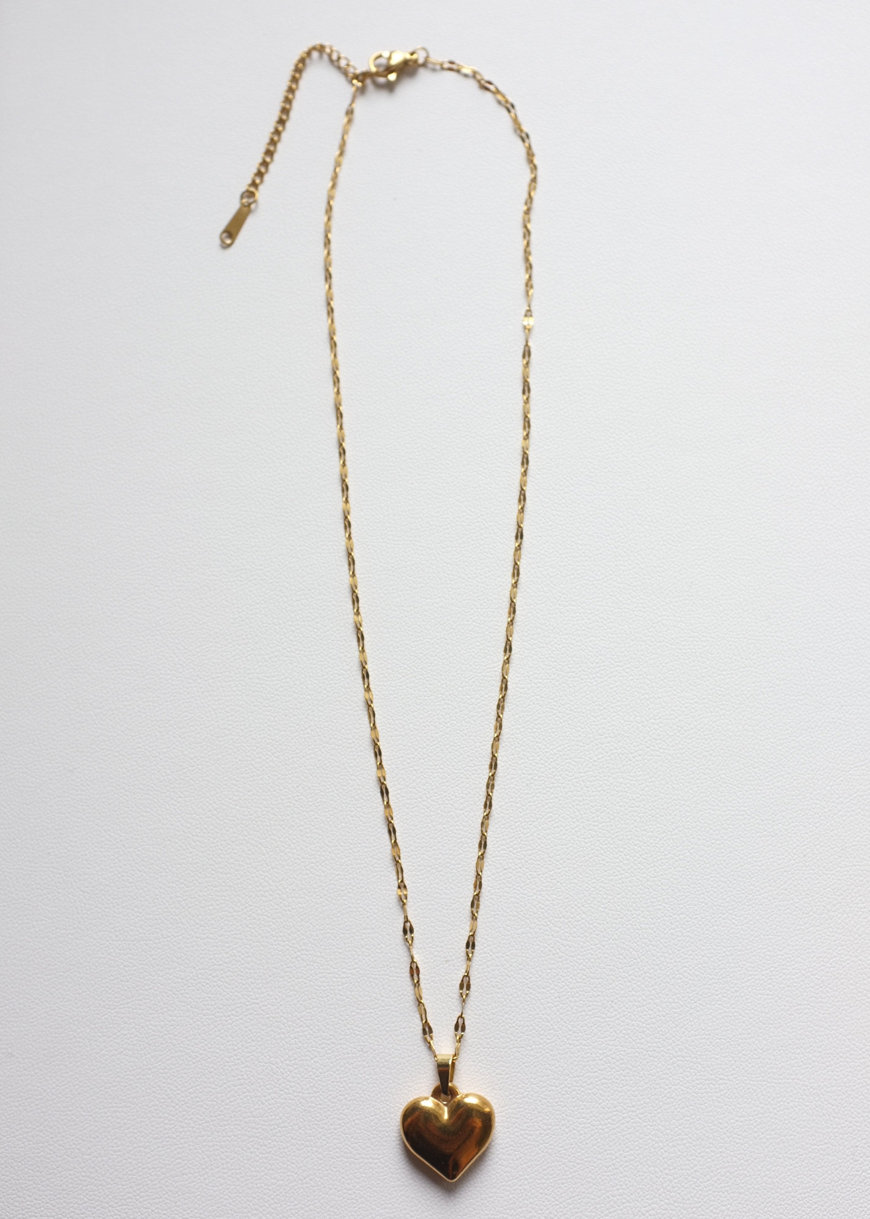 gold stainless steel chaine with bold heart pendant on white background