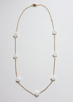 A stainless steel chain necklace with freshwater shell flower beads, featuring a gold-tone chain and white beads.