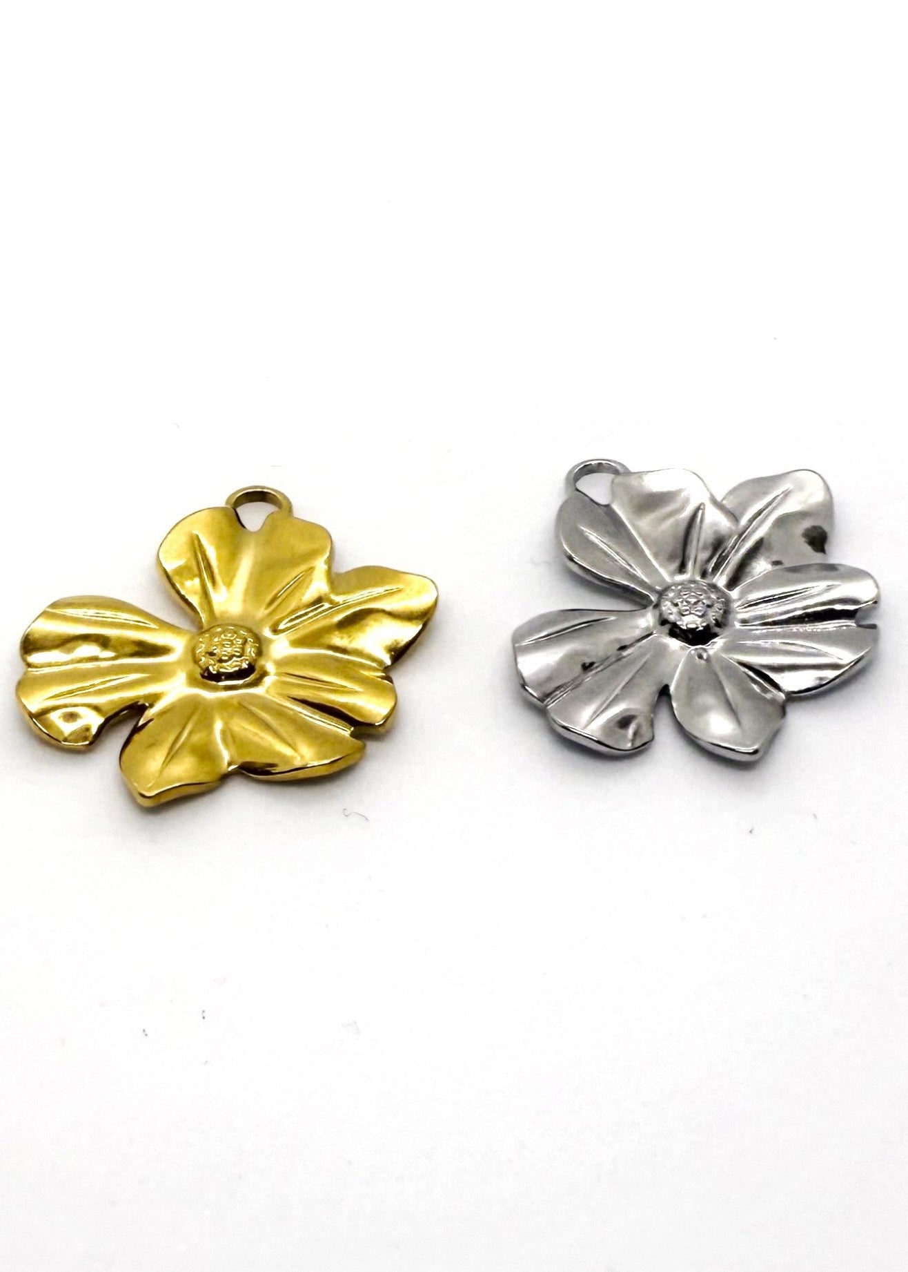 Gold and silver stainless steel flower-shaped charms on a white background