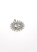 Silver sun-shaped charm with face design on a white background