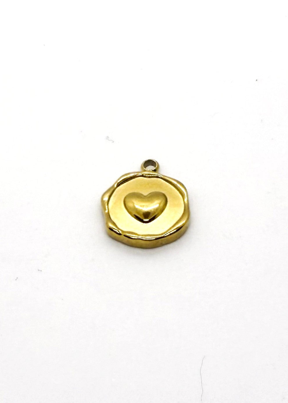 Gold stainless steel locket with a heart design on a white background