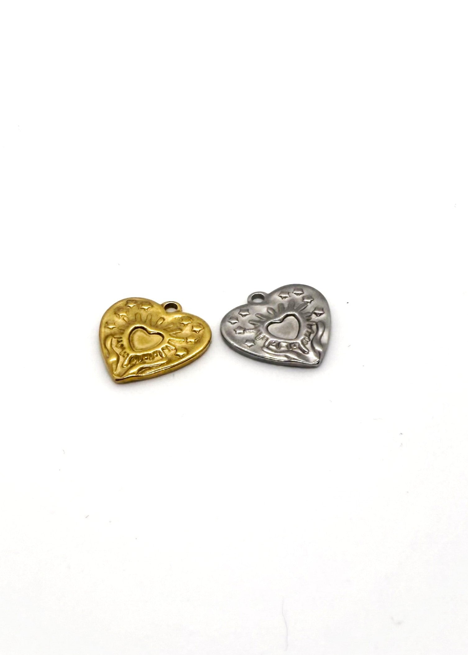 Two stainless steel heart-shaped charms, one gold and one silver, on a white background.