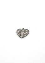 Silver stainless steel heart-shaped charm with engraved details on a white background