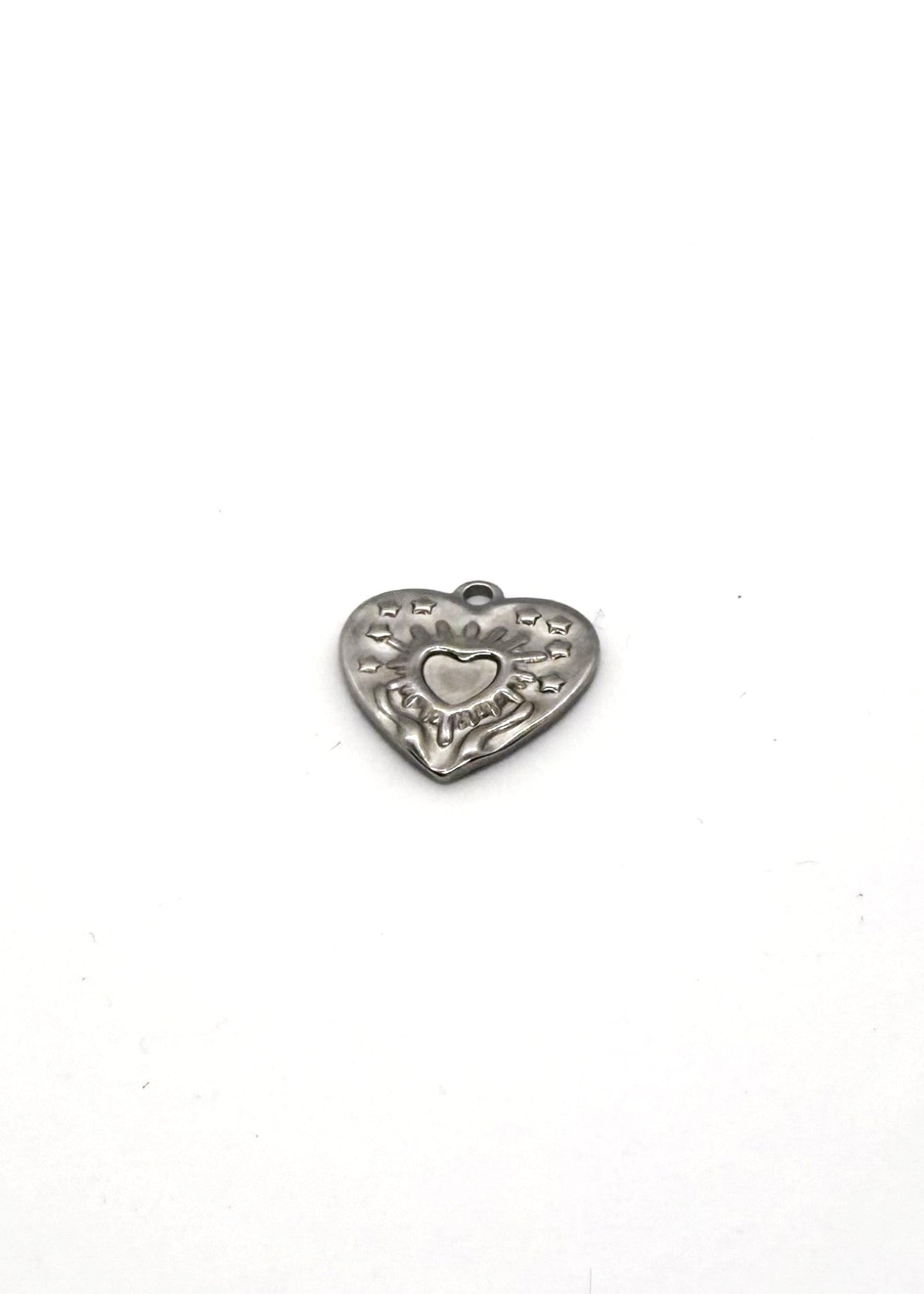 Silver stainless steel heart-shaped charm with engraved details on a white background