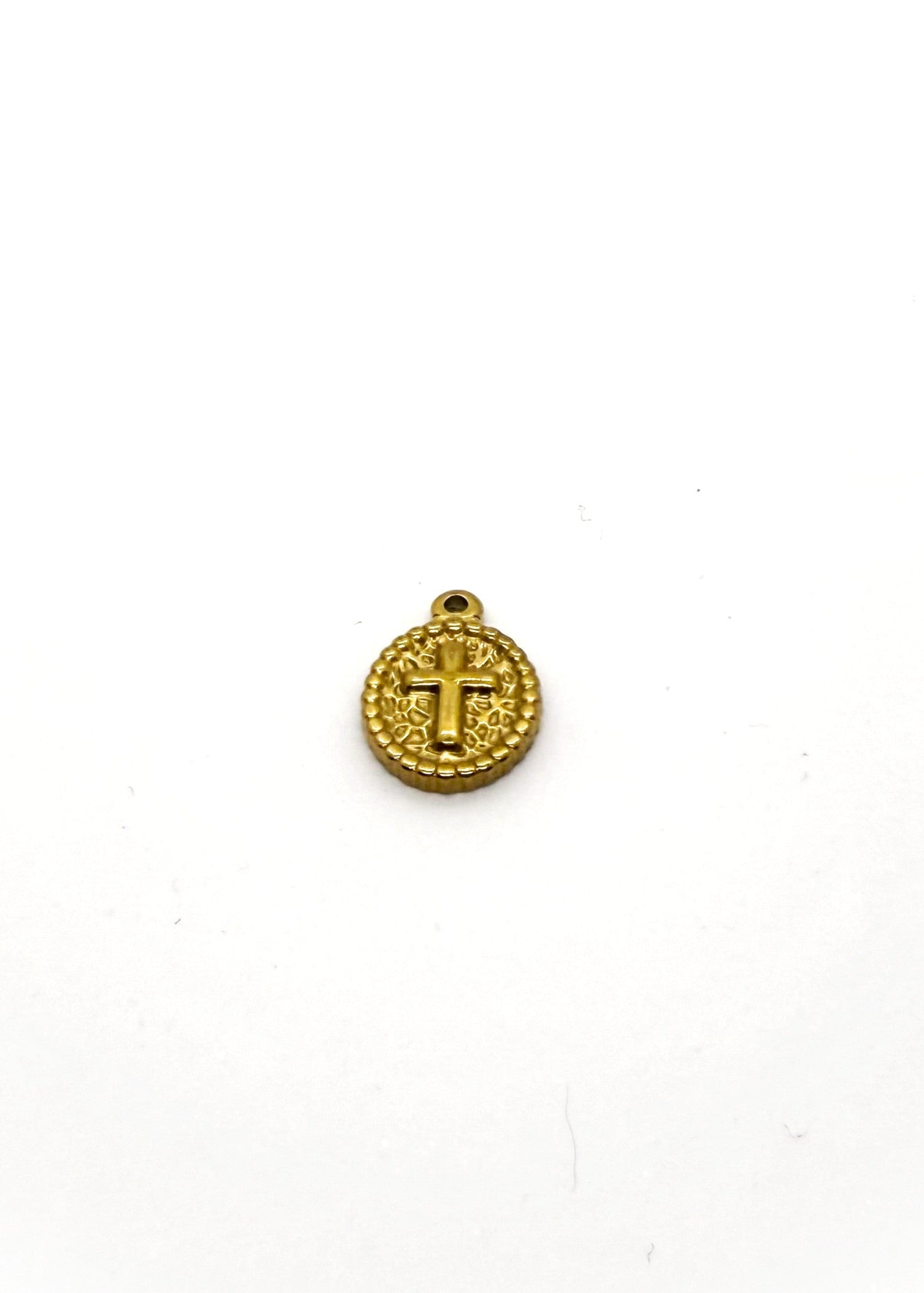 Gold stainless steel Oval shaped cross charm on white background
