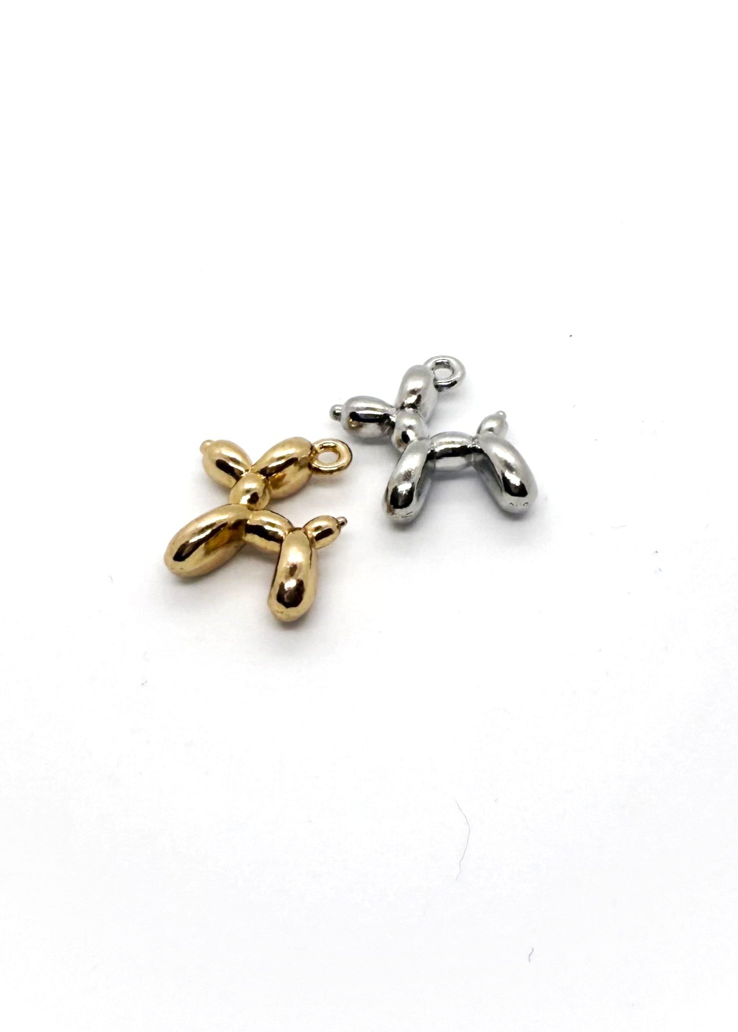 Gold and Silver Stainless Steel ballon dog charms on white background