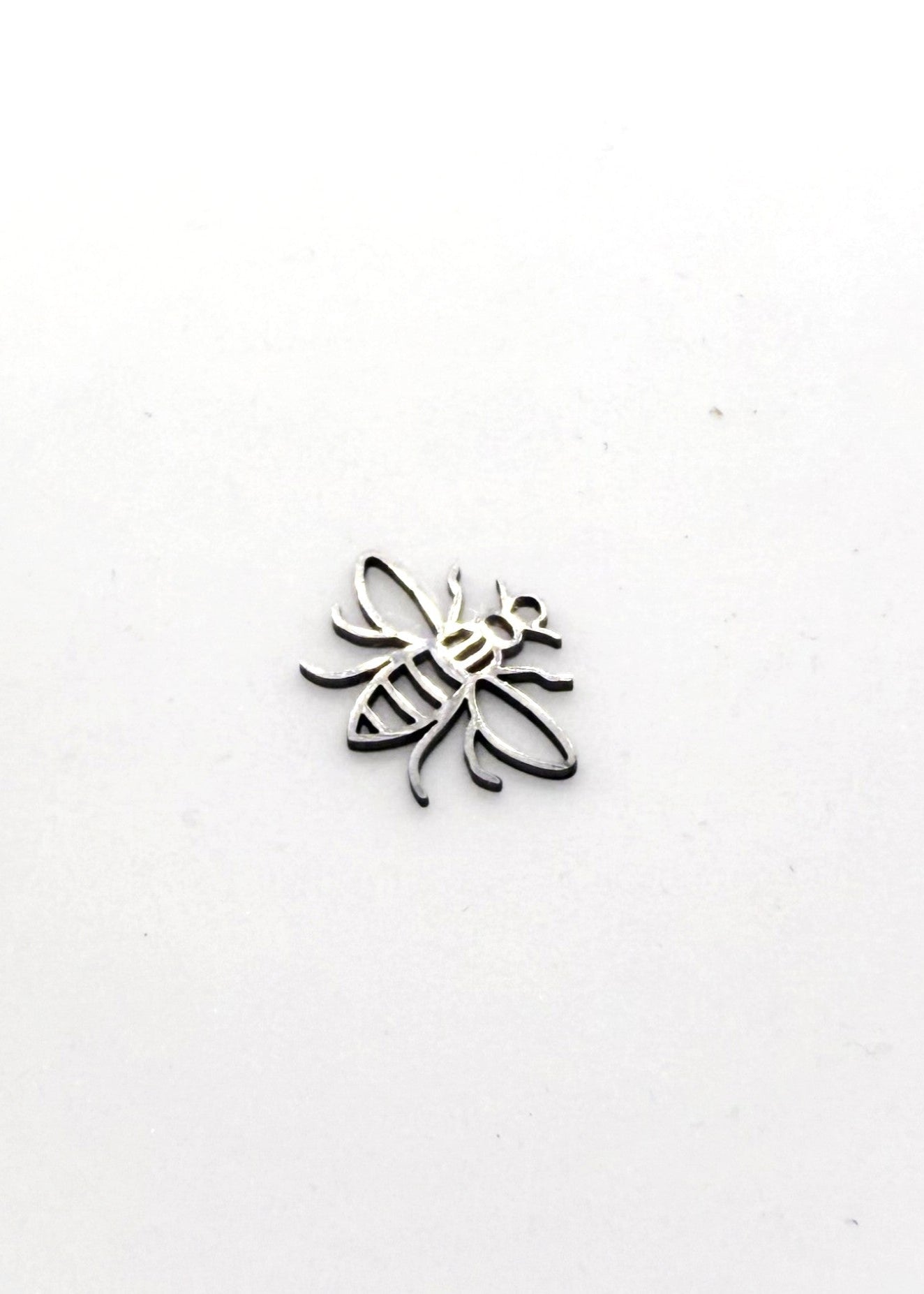 Silver stainless steel bee-shaped charm on a white background