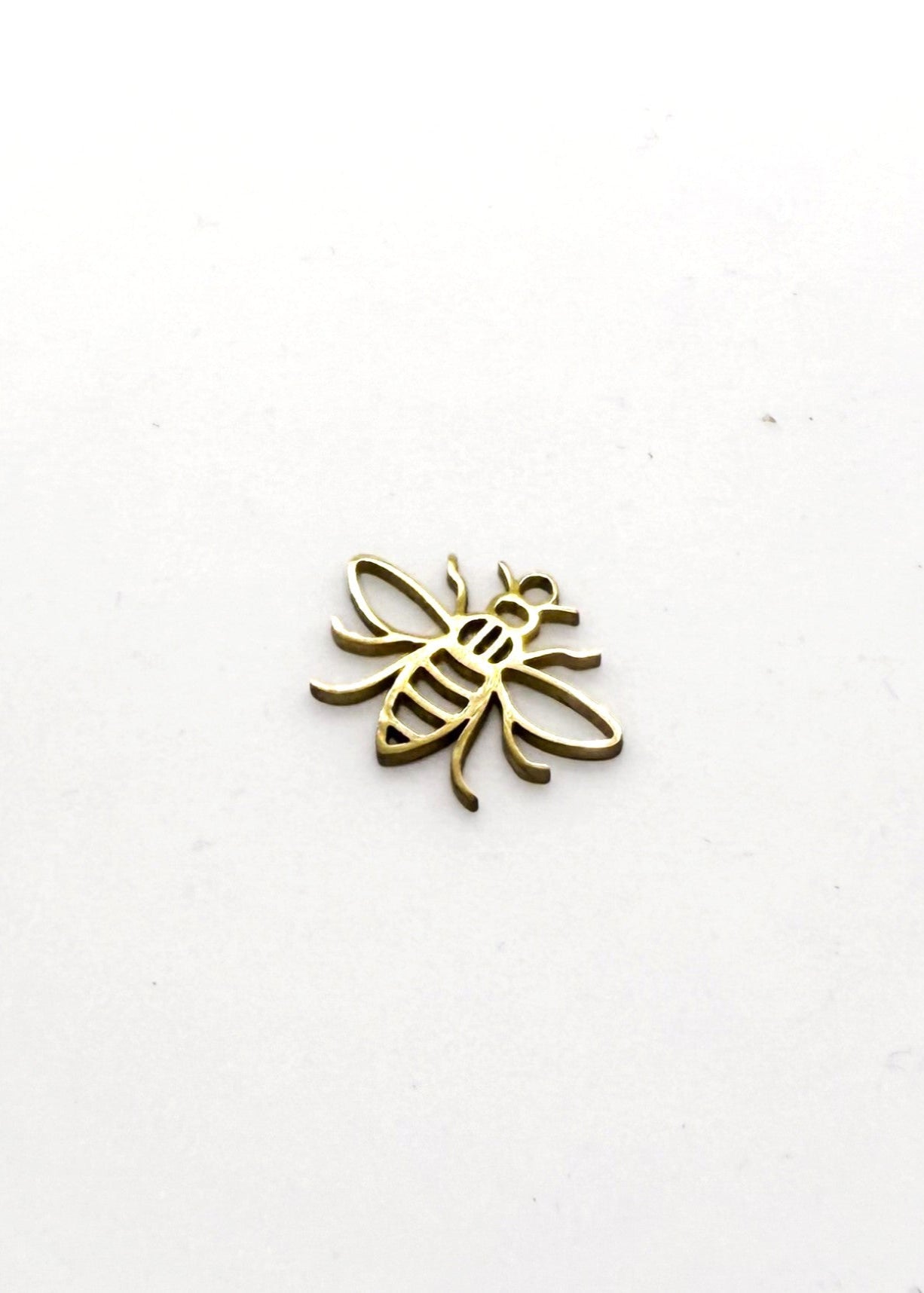 Gold stainless steel bee-shaped charm on a white background