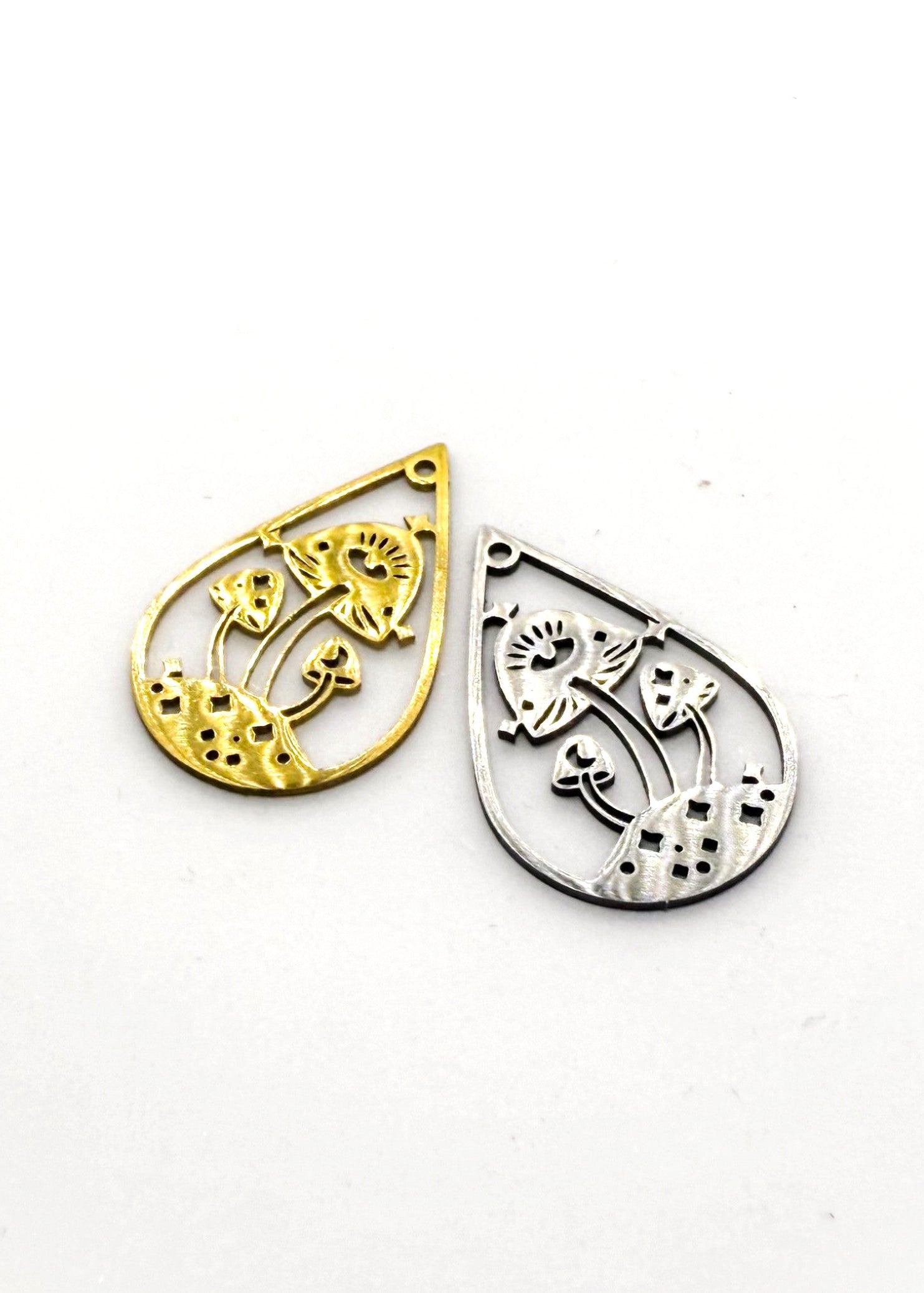 Gold and silver stainless steel teardrop-shaped charms on a white background