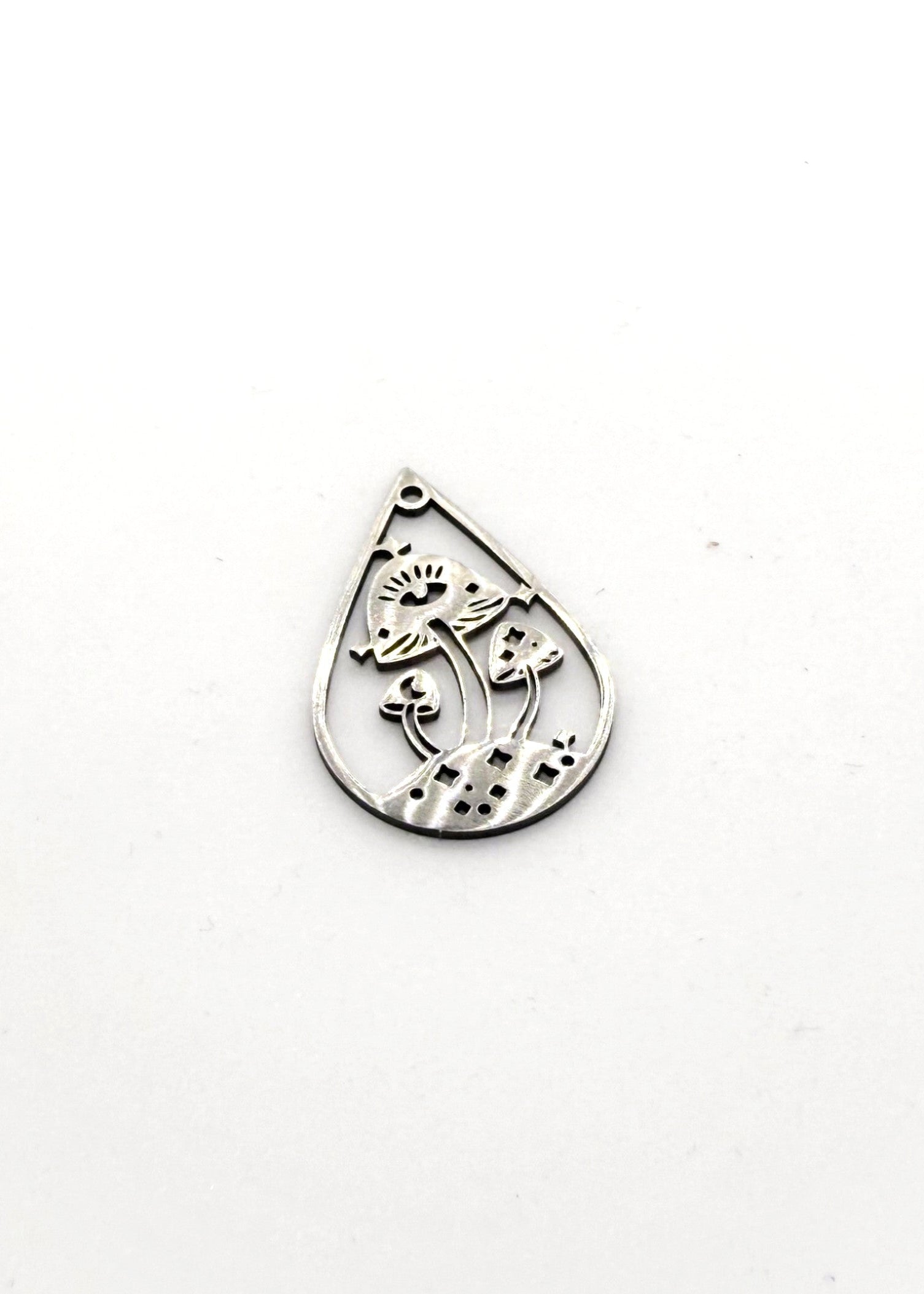 Silver stainless steel teardrop-shaped charm with intricate design on a white background