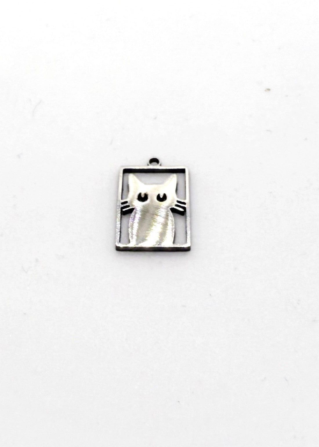 Silver stainless steel cat-shaped charm on a white background