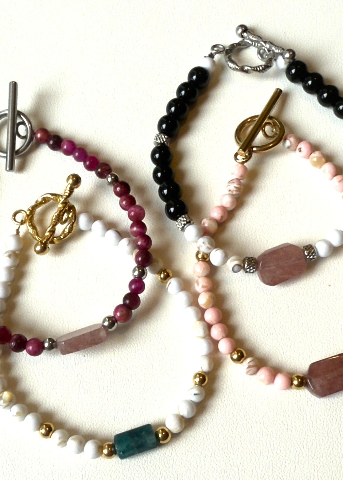 Set of beaded bracelets with various colors and designs on a white background