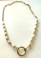 Freshwater pearl and oval link chain with a gold ring charm holder on a white background